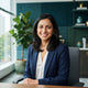 A friendly South Asian woman smiling in a bright, modern office setting, representing a satisfied customer.