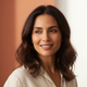 A smiling woman in her late 30s with radiant skin, conveying satisfaction and trust.