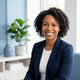 A diverse woman smiling confidently in a bright, modern studio space, representing a satisfied customer.